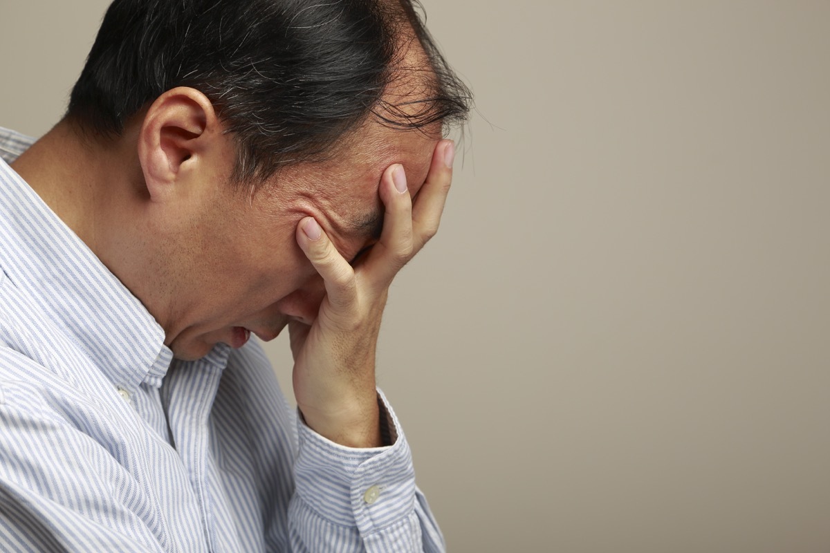 man holding head in frustration or pain