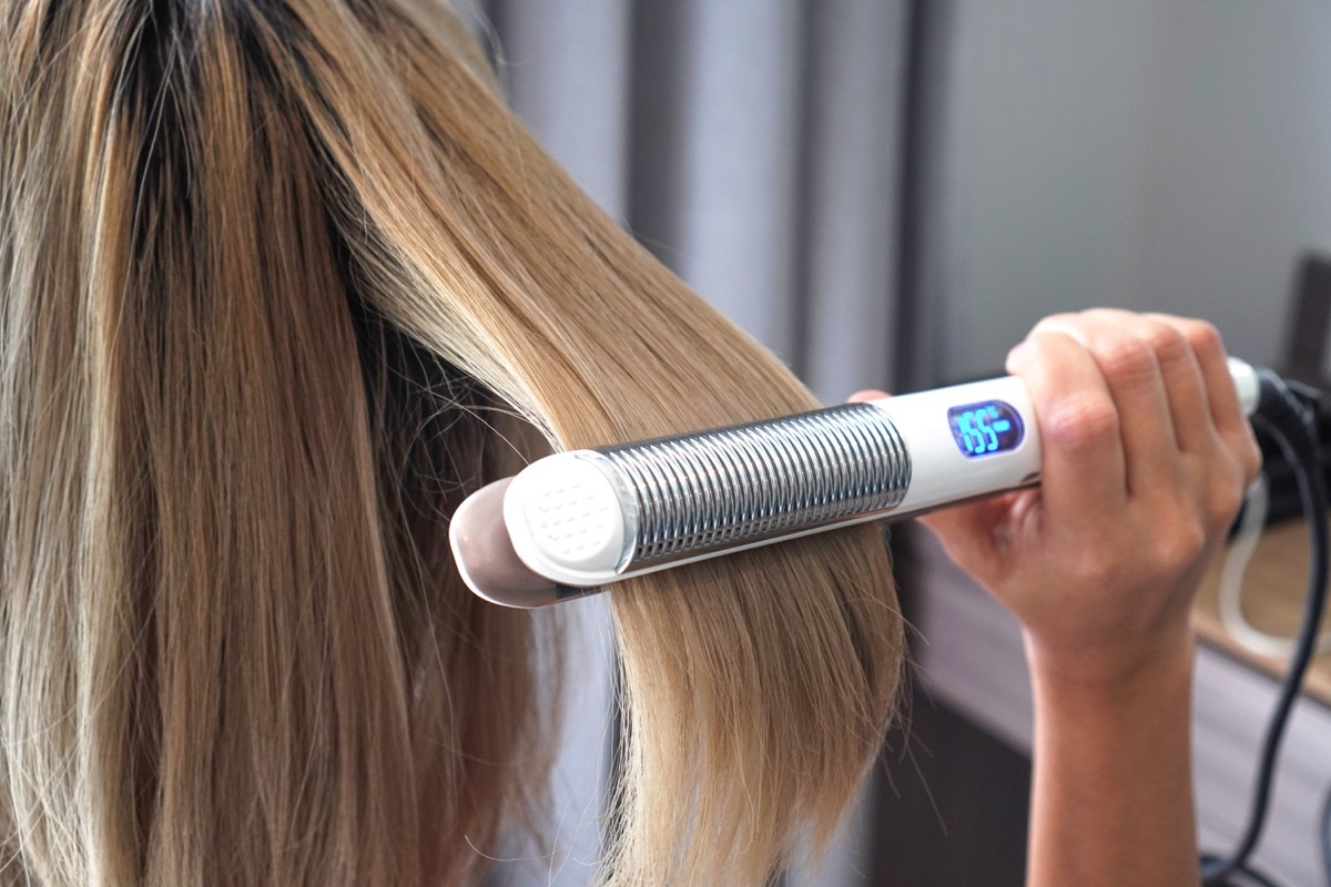 Woman using a hair straightener tool