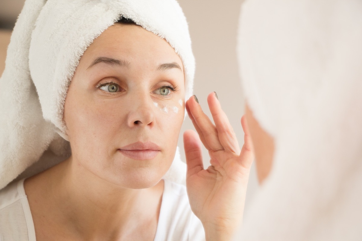 middle-aged white woman applying eye cream