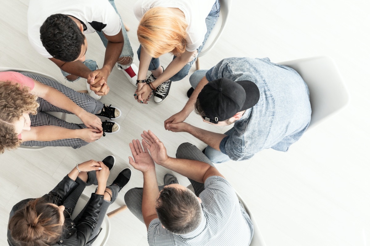 Top view on difficult youth talking to a therapist while sitting in a circle during meeting