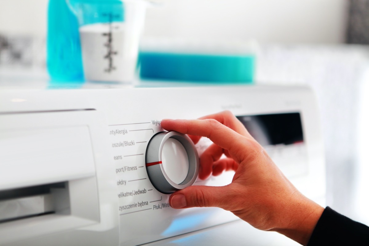 Close up of woman hand adjusting washing machine