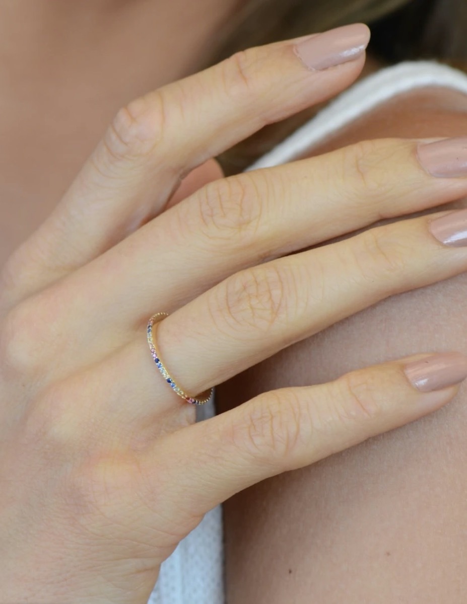 woman's hand with rainbow eternity band on it