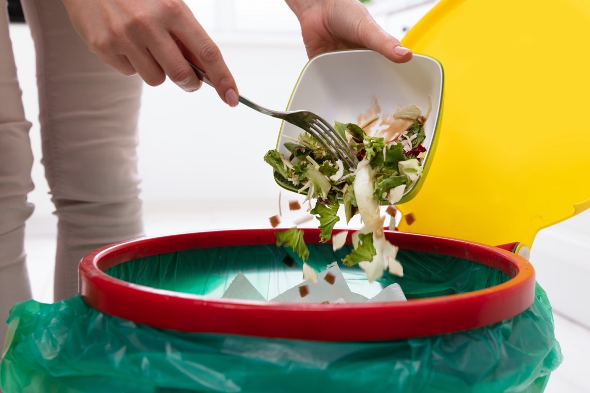 person throwing away salad