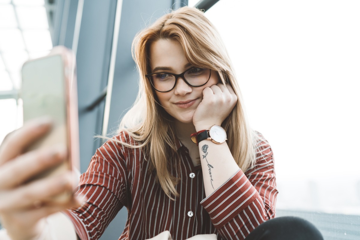 young girl taking selfie with tattoo in the office