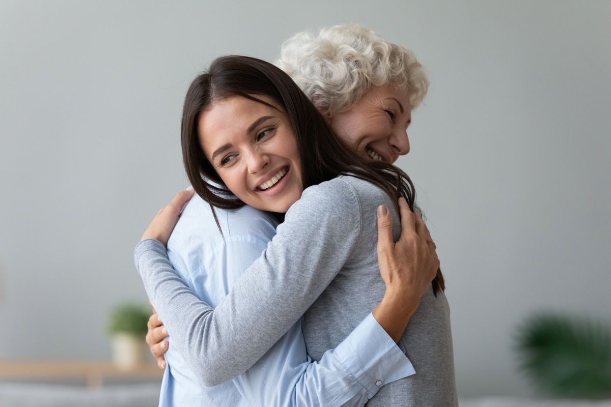 senior woman hugging younger woman