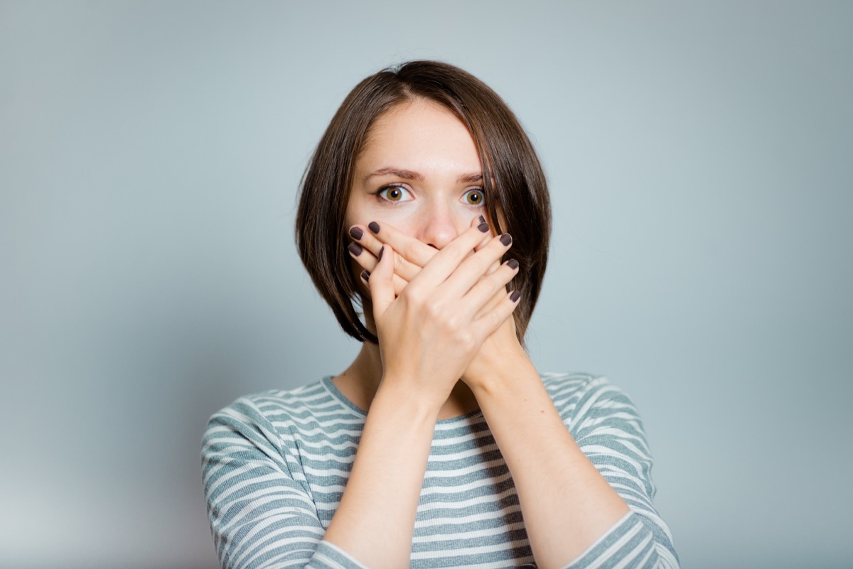 woman holding her hands up to her mouth