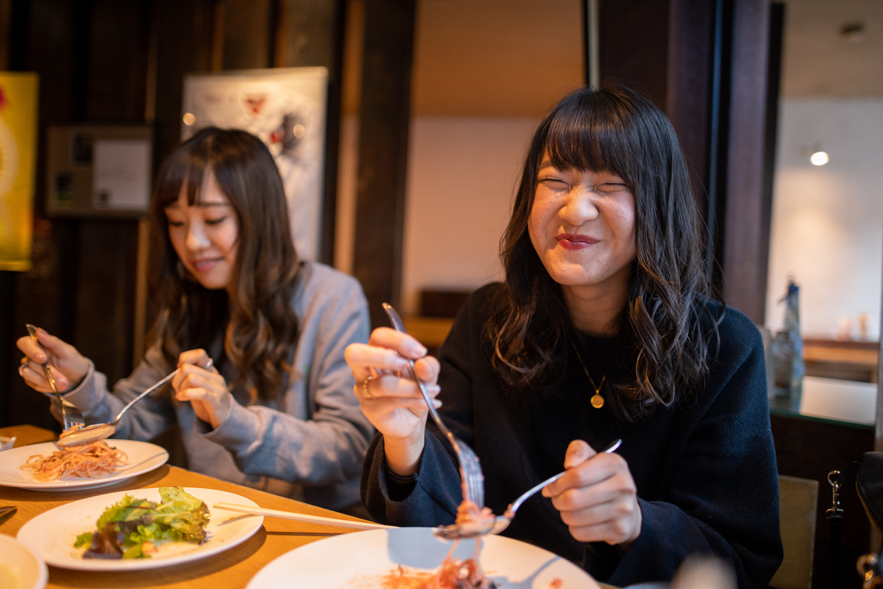 Happy young woman eating lunch at cafe