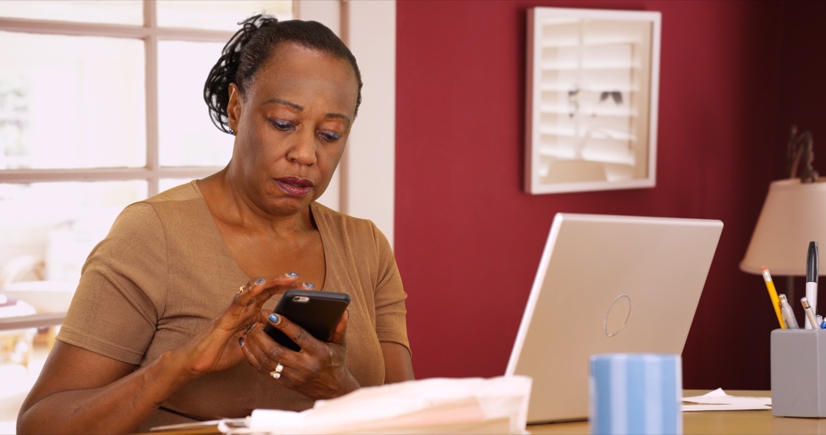 woman uses her phone and laptop