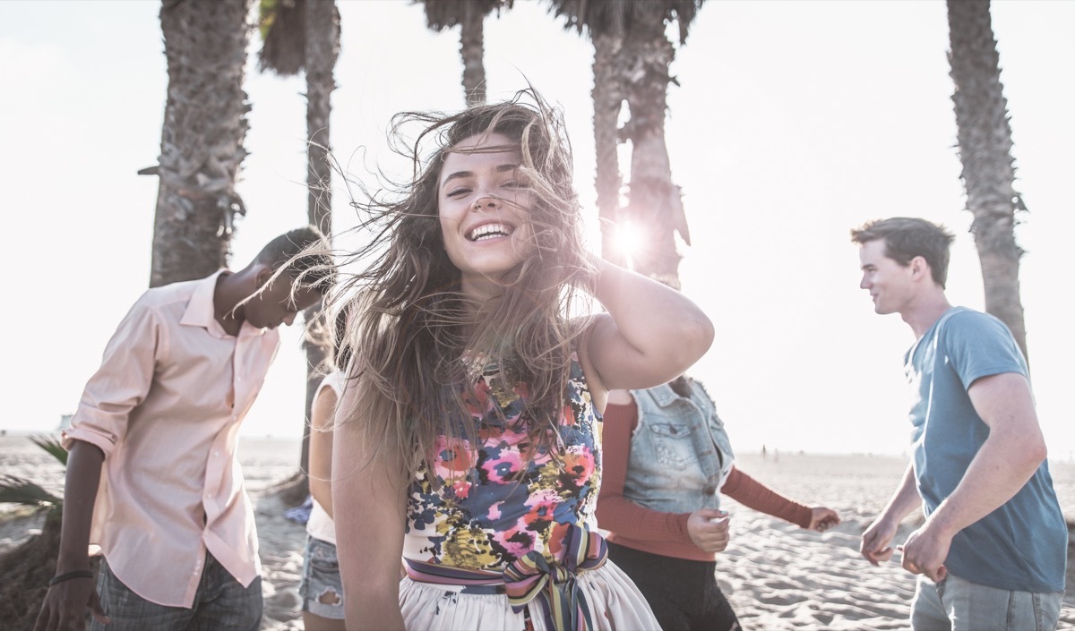 people dancing on a beach with palm trees