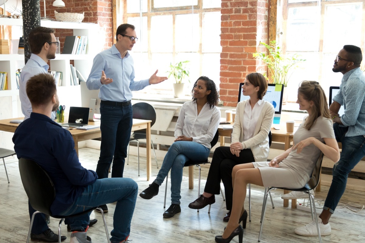 man speaking to team of employees