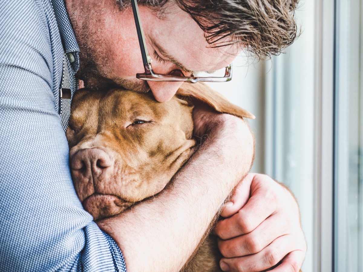 man hugging his dog