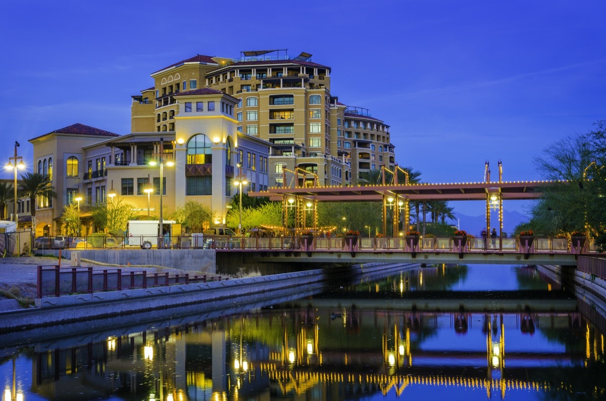 cityscape photo of a canal reflection in the foreground and downtown Scottsdale, Arizona at night