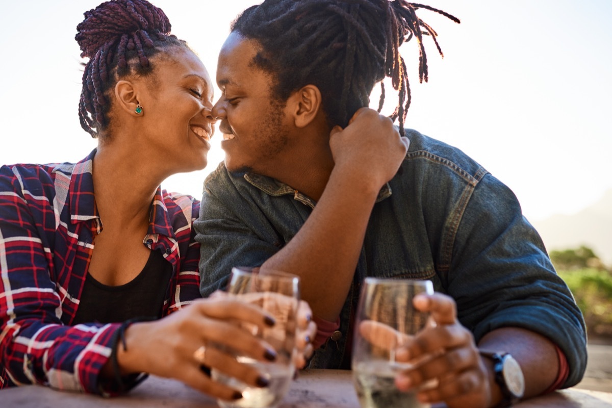 Black couple kissing and enjoying some wine on a date