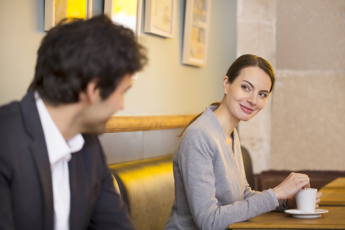 man trying to hit on a woman in a cafe with a few flirty jokes