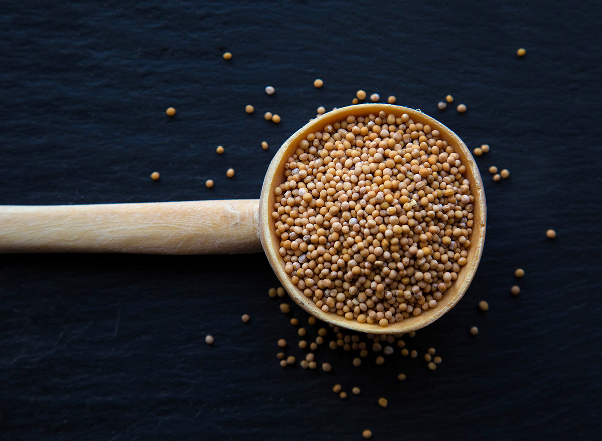 mustard grains in wooden spoon