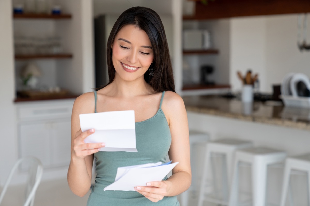 happy young woman reading letter