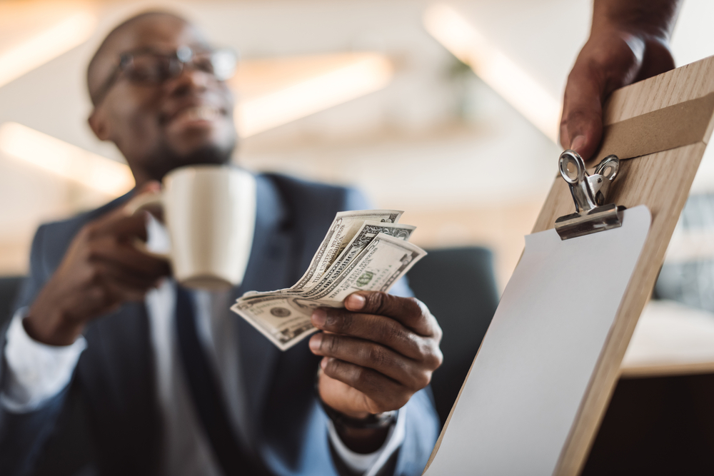 A man handing someone a cash tip