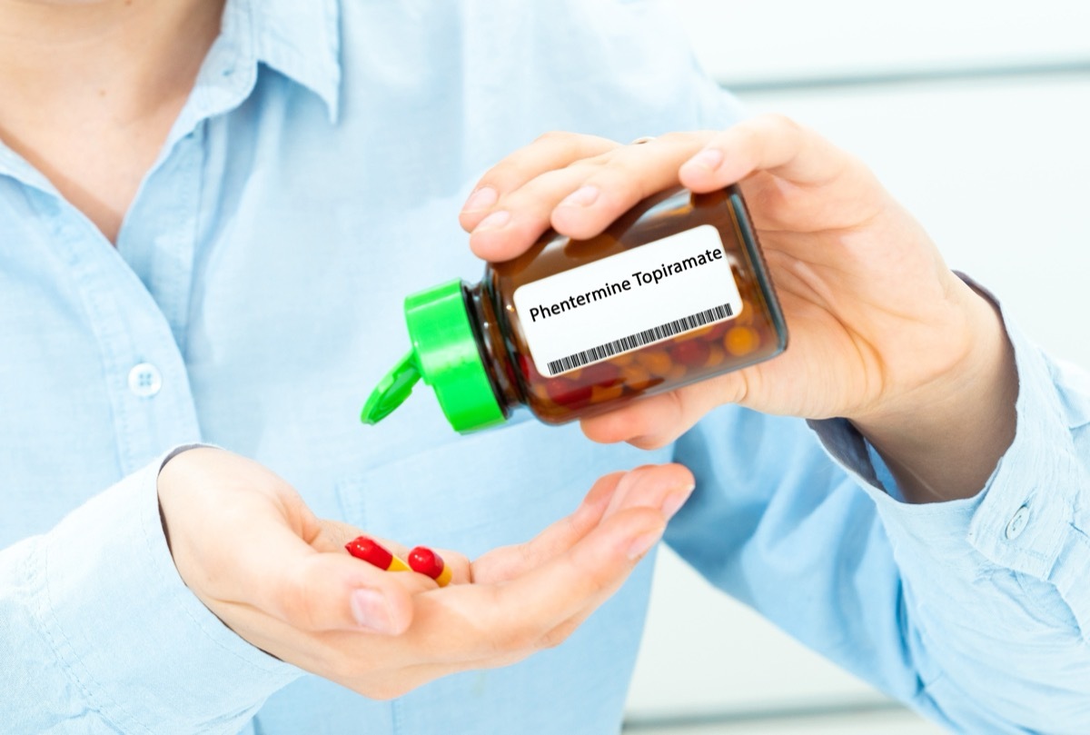 Woman Hand holding on open palm with Phentermine Topiramate pill tablets