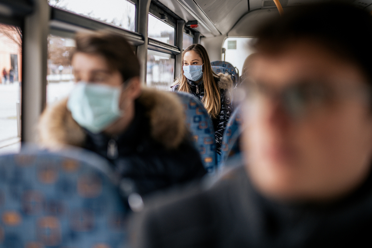 Woman wearing face mask on bus because of the new Coronavirus 