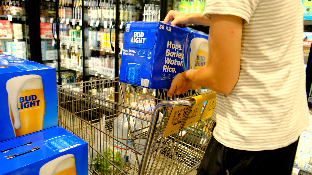 Shopper grabbing a case of Bud Light brand beer