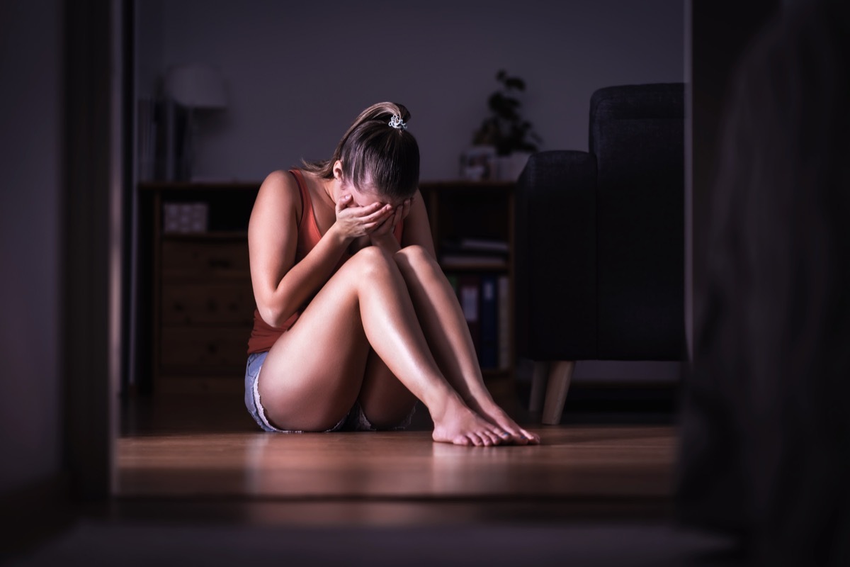 depressed woman sitting on the floor