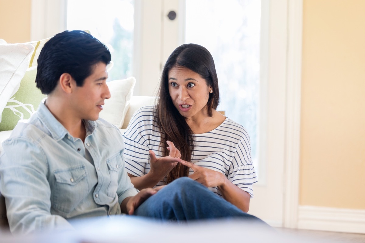 latina woman talking to her latino husband who seems bored