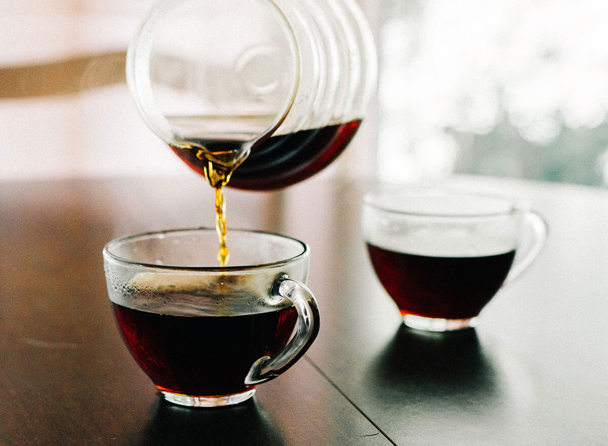 Cup of pour over coffee being poured into a mug in the morning.