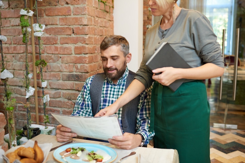 man and waitress looking at menu