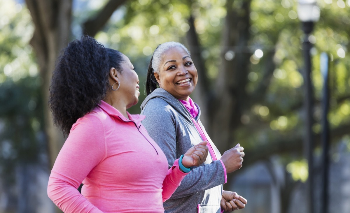 two middle aged black women power walking outside together