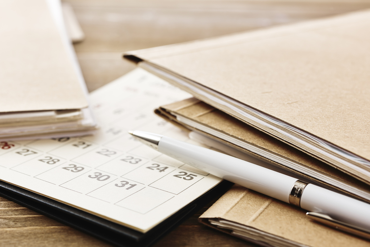 Pile of papers paperwork on office wooden desk table