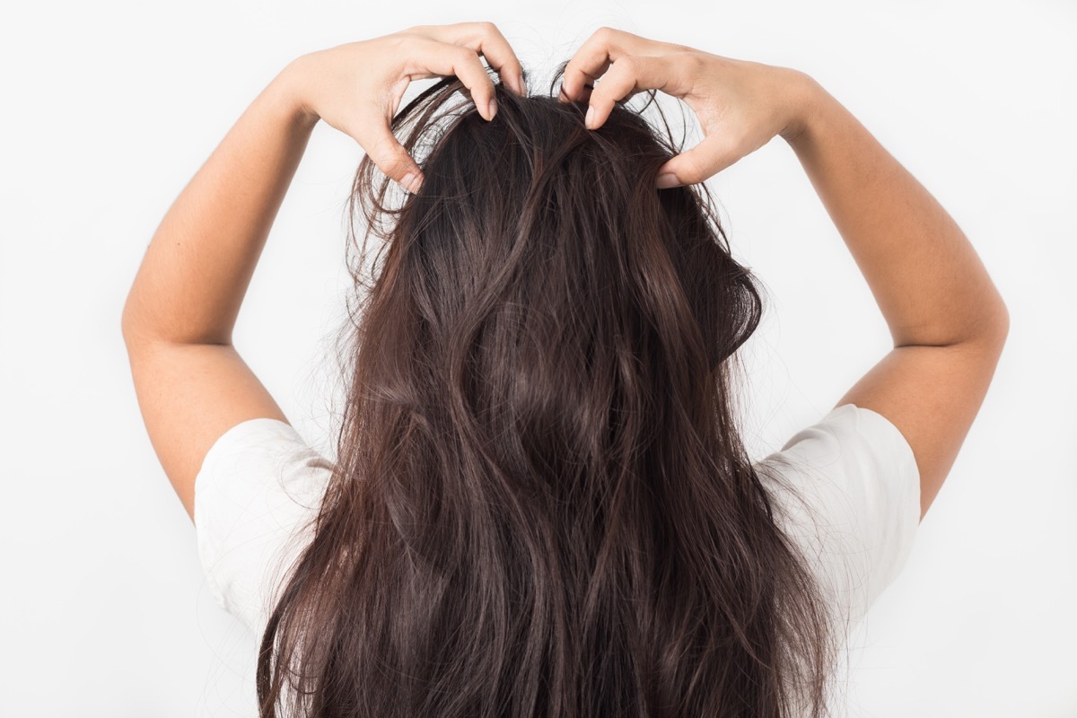 Woman giving herself a scalp massage