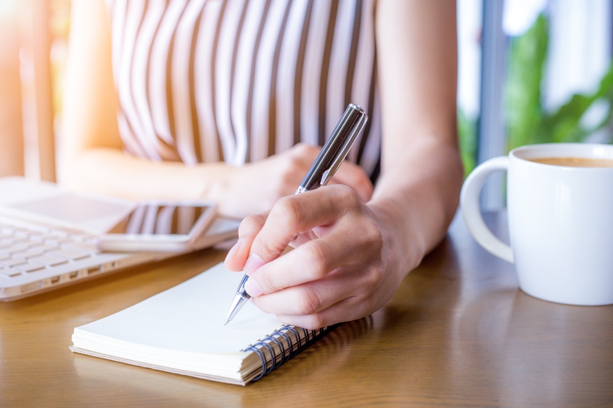 woman writing on her notebook