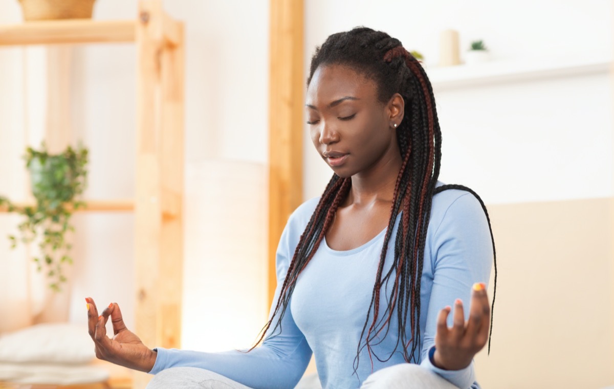 Woman Meditating In Lotus Position Sitting In Bed Indoor In The Morning. Selective Focus