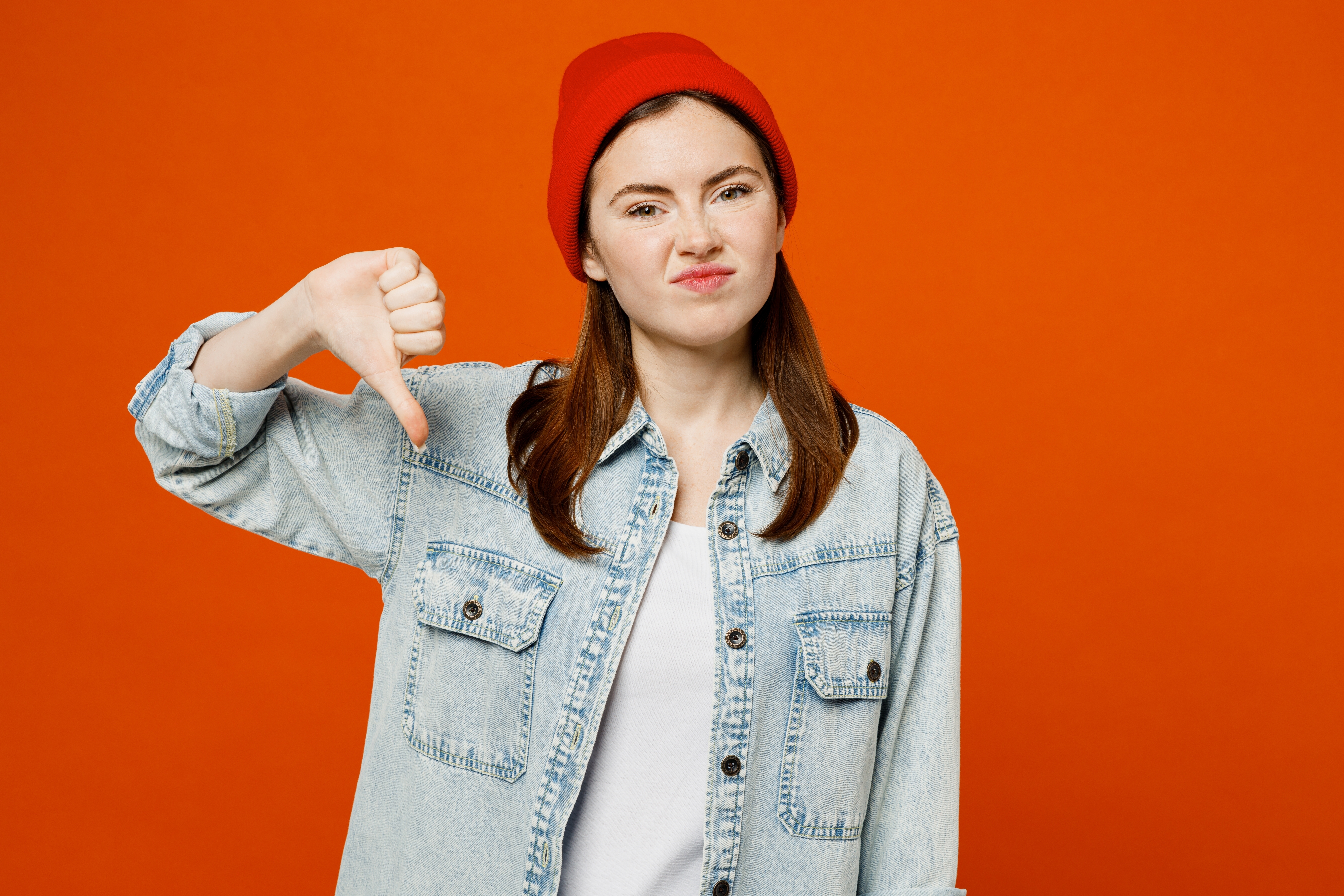 Woman in orange thumbs down