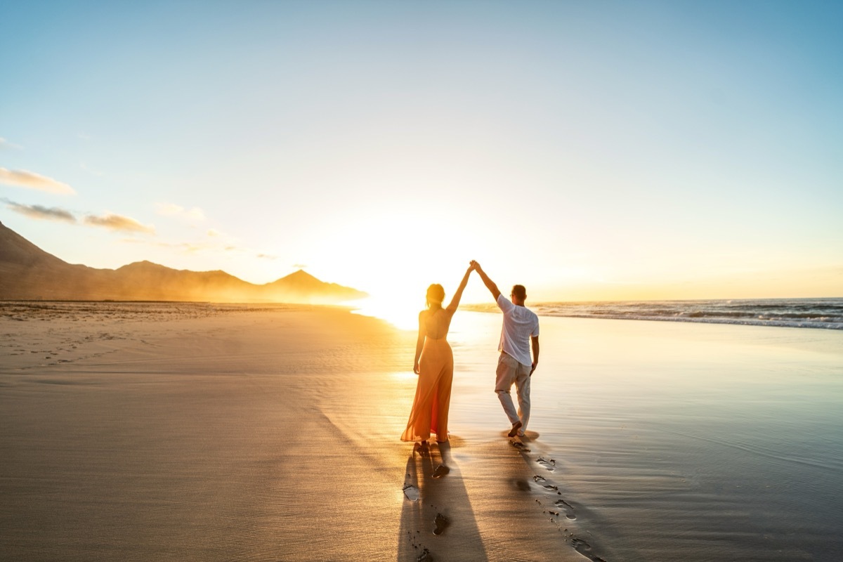 Couple Walking Along the Beach at Sunset