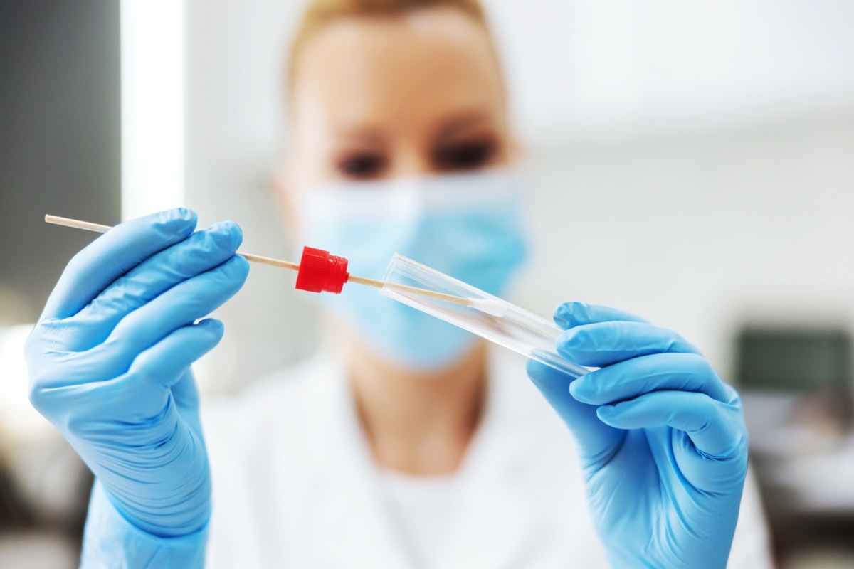 Woman holding COVID testing swab