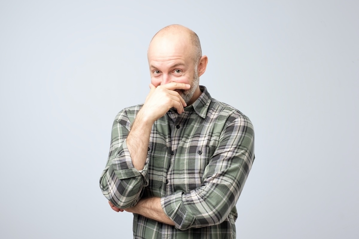 Older white man covering a laugh