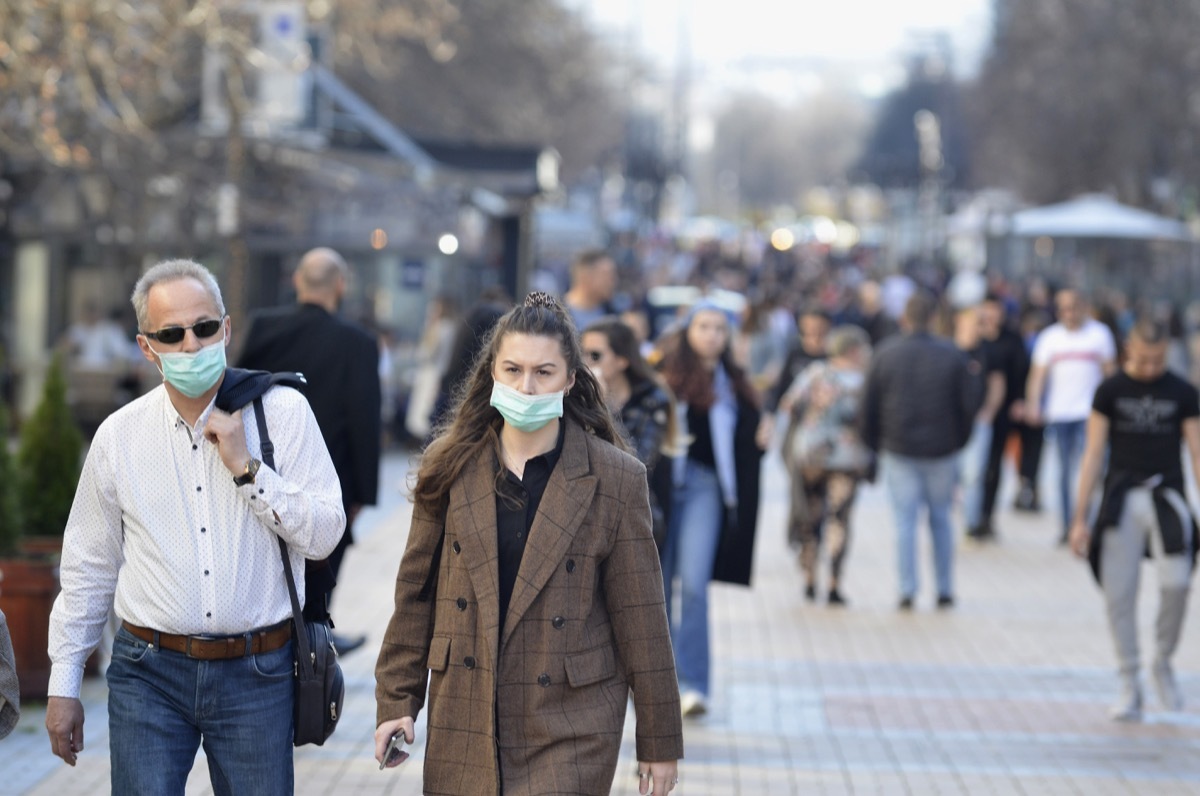 Sofia, Bulgaria - MAR 13 2020: A young woman and an older man are walking on Vitosha street. Few hours after that the Governemnt announced State of Emergency in the country because of the corona virus outbreak.