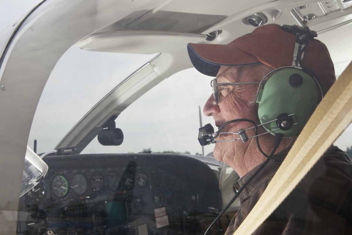 veteran in and flying a plane with blue headphones