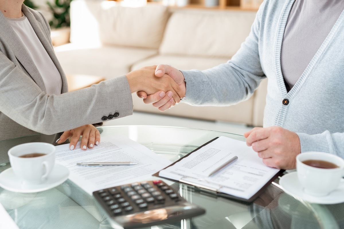 Handshake of young elegant businesswoman and her mature colleague or partner in casualwear after signing documents