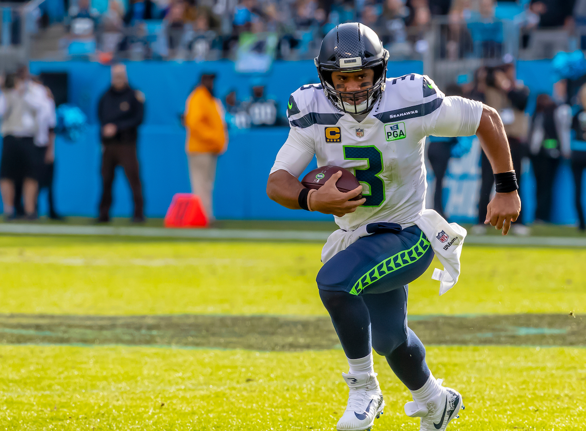 A Seattle Seahawks player running on the field holding the football