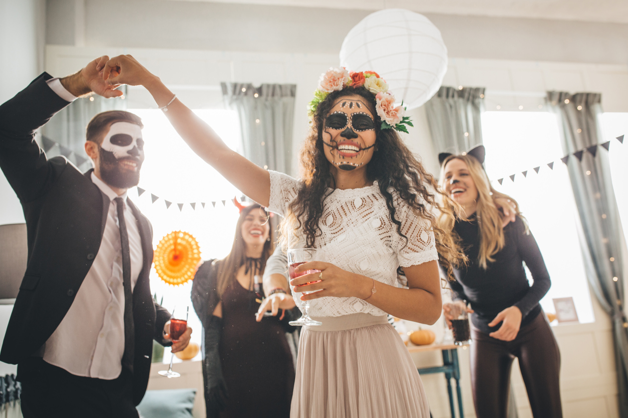 Group of Young people at home celebrating Halloween in costumes, they enjoy in good atmosphere