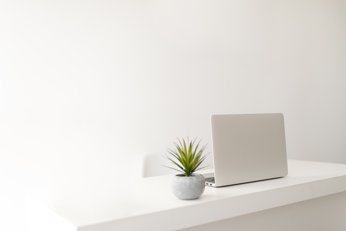 white minimalist home office with laptop of table