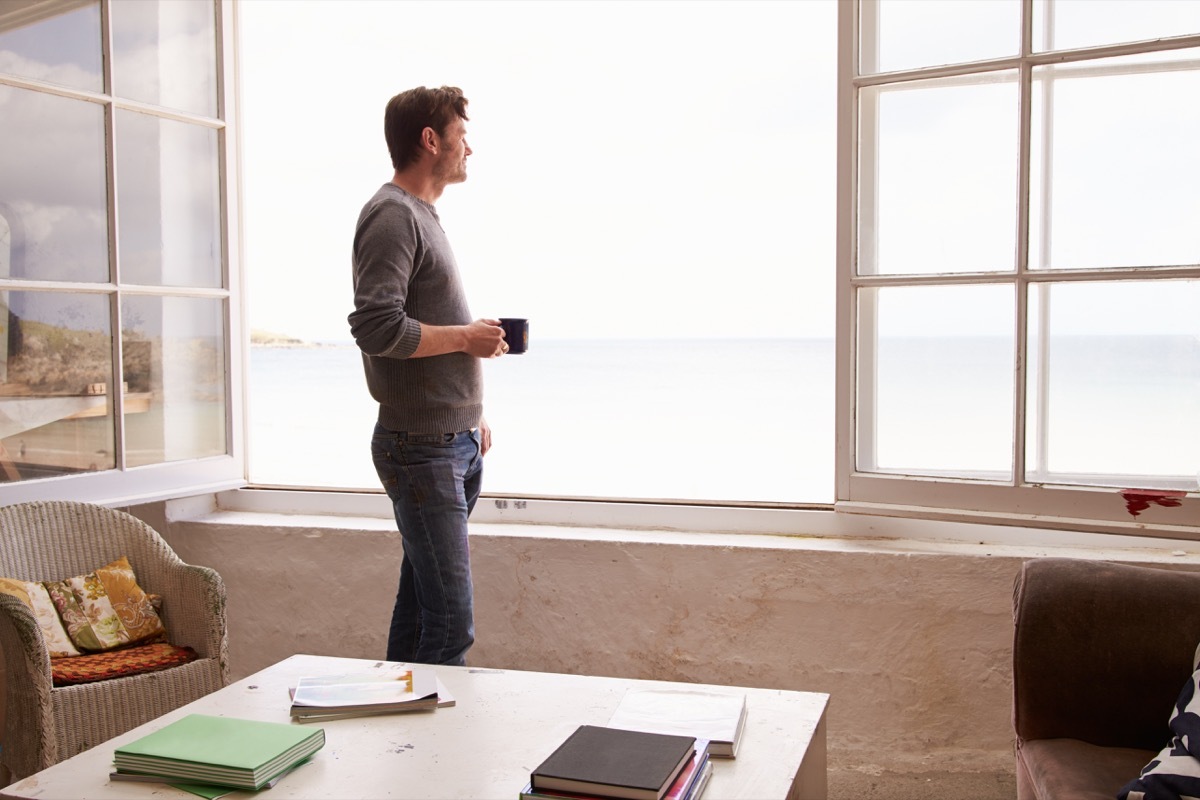 Man Looking out window thinking happier life in 2019