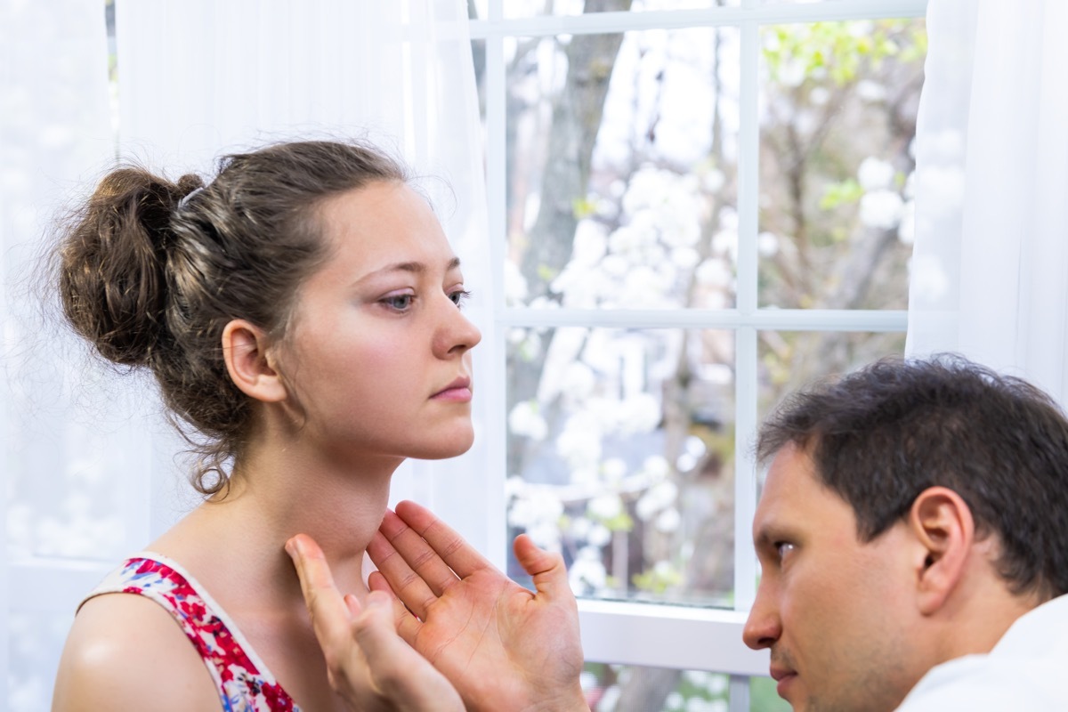 a woman with a goiter on her neck gets a doctor checkup