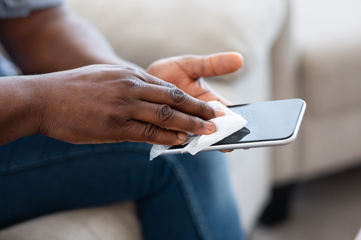 man hands wipe the touch screen phone antibacterial wipes