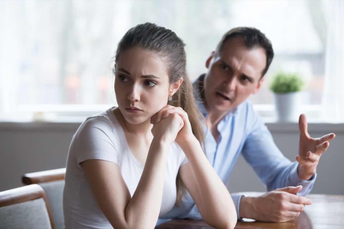 Offended woman sitting back to lover looking away avoiding talking