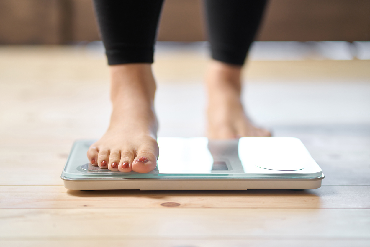 A close up of a person's feet as they step onto a scale