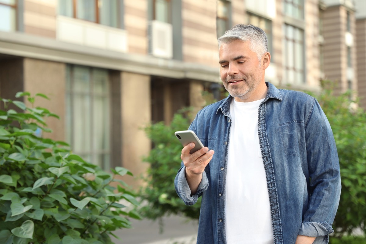 man walking and texting on his phone