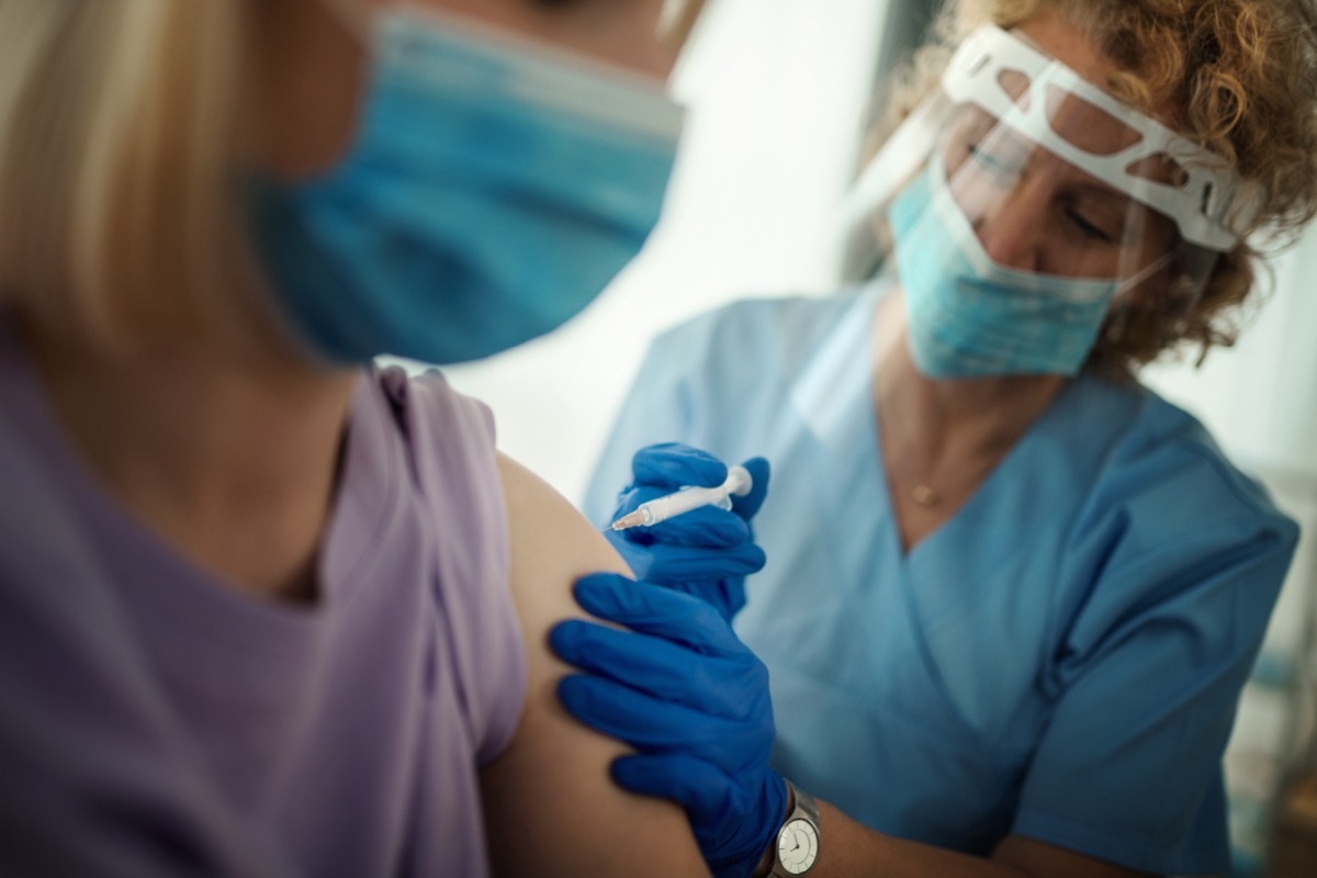 Closeup side view of a young woman having Covid-19 vaccine.